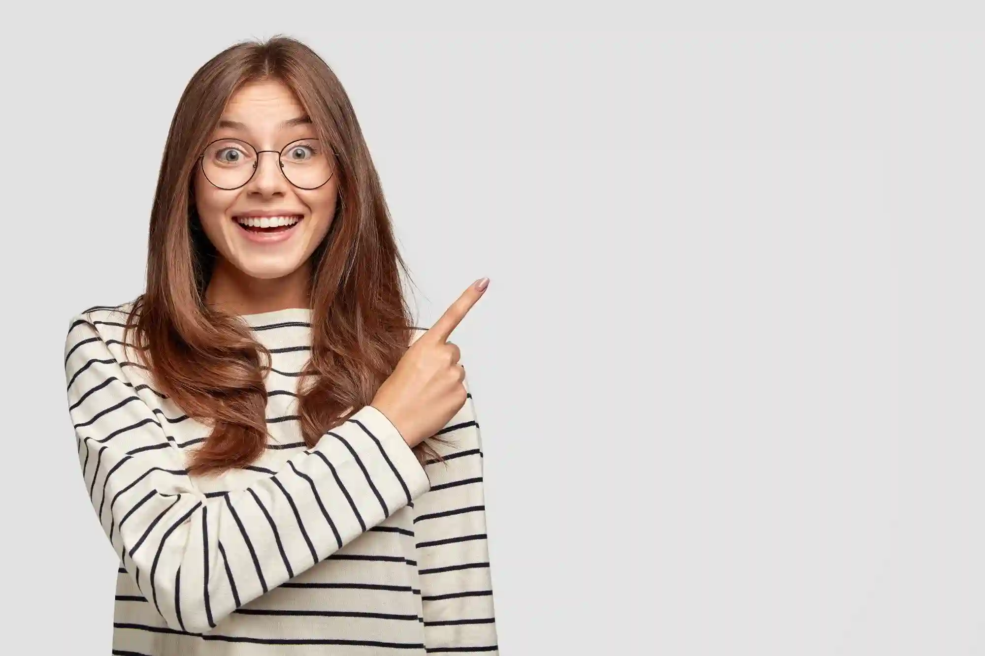 A young woman is pointing to the IGCSE - ICT 0417 subject with excitement. She is smiling and has a look of determination on her face.