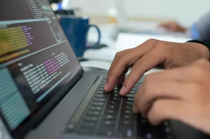 A young man is working on Git with a focused and determined expression on his face. His enjoyment of the task is evident.